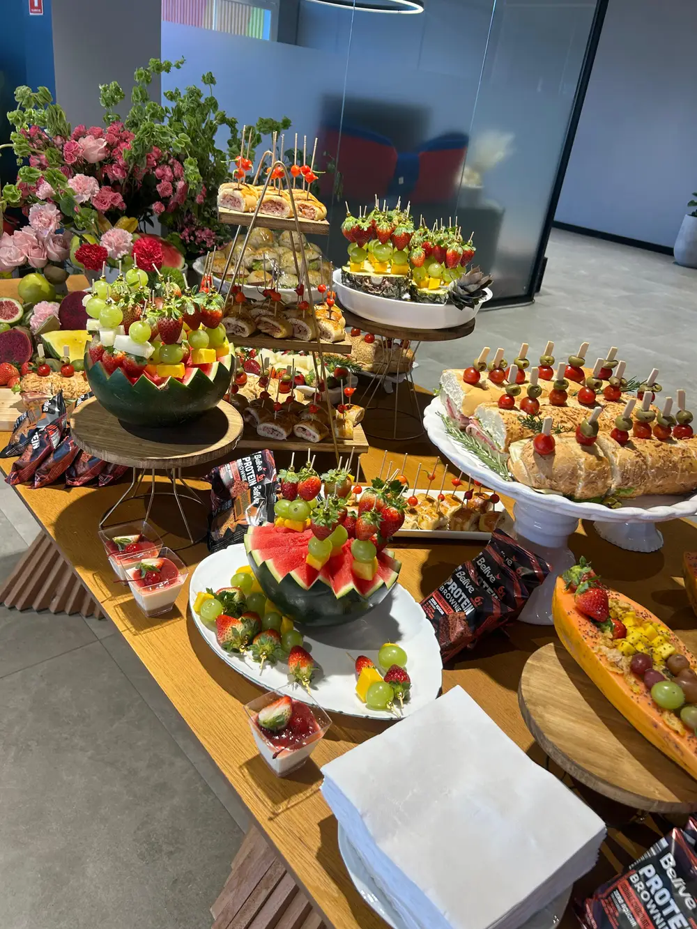 Mesa de coffee break corporativo da Cake Delivery com frutas, salgados e doces